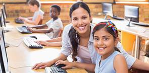 Image of female teacher helping girl on computer