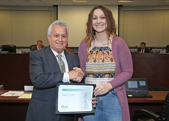 Trustee Zeke Hernandez presents Blaysen Varnado with certificate